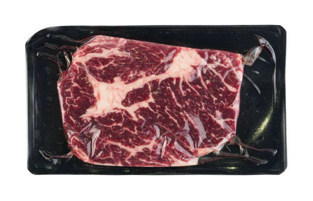 Vacuum black plastic pack with fresh beef steak isolated stock photo