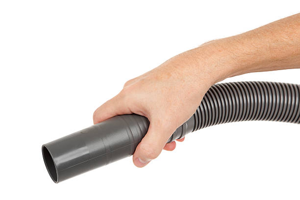 vacuum cleaner hose in hand - stofzuigen stockfoto's en -beelden.
