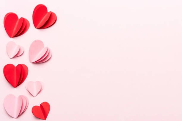 Valentine's Day background with red hearts and gift box on pink background with copy space stock photo