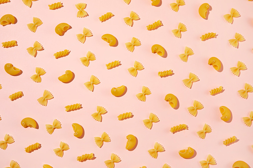 Variation of Italian pasta on pink background