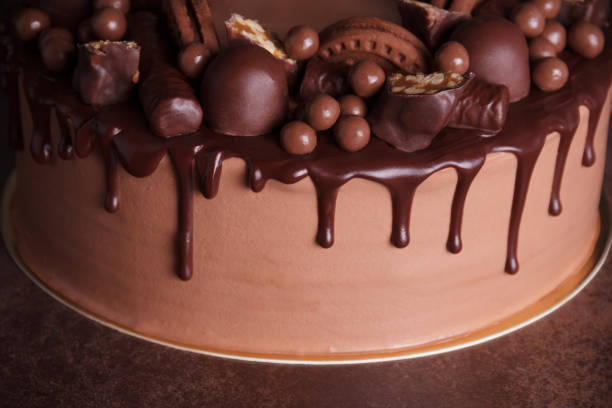 Variety of chocolate decorations and drips of icing on delicious chocolate cake stock photo
