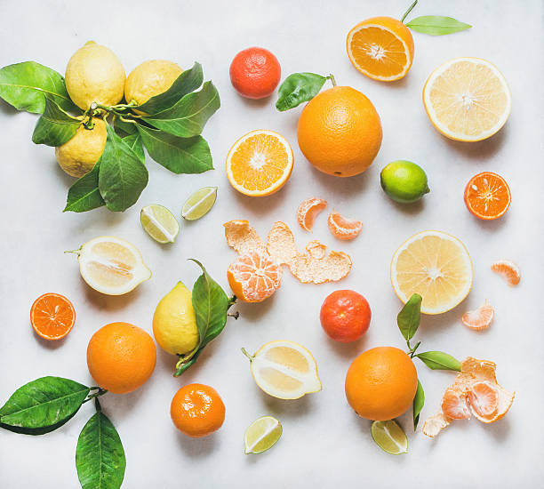 Variety of citrus fruit for making healthy smoothie or juice Variety of fresh citrus fruits for making juice or smoothie over light grey marble table background, top view. Healthy eating, vitamin, detox, diet food, clean eating concept citrus fruit stock pictures, royalty-free photos & images