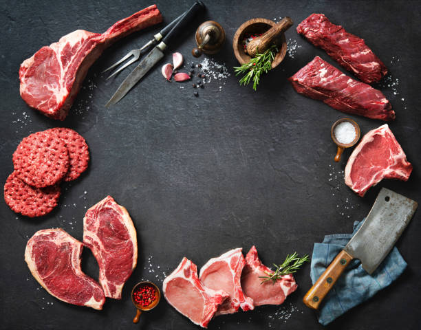 Variety of raw cuts of meat, dry aged beef steaks and hamburger patties stock photo