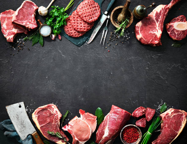 Variety of raw cuts of meat, dry aged beef steaks and hamburger patties stock photo
