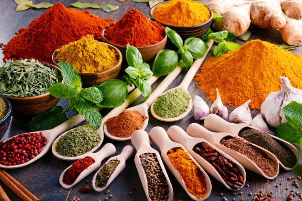 Variety of spices and herbs on kitchen table stock photo