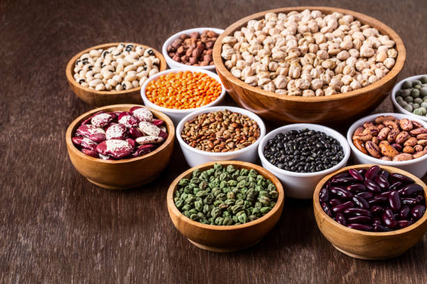 Various assortment set of indian legumes in bowls on wooden background stock photo