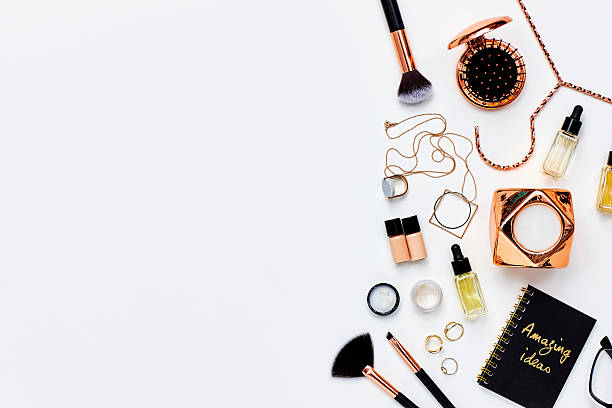 Directly above shot of various beauty products and jewelry. Personal accessories are placed on white background. The blank space can be used for advertisement purpose.