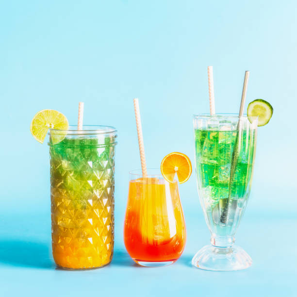 Various colorful summer refreshing lemonade or long drinks with ice cubes and cocktails in glasses stock photo