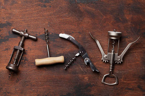Various wine corkscrews on wooden table. Top view flat lay with copy space for your text