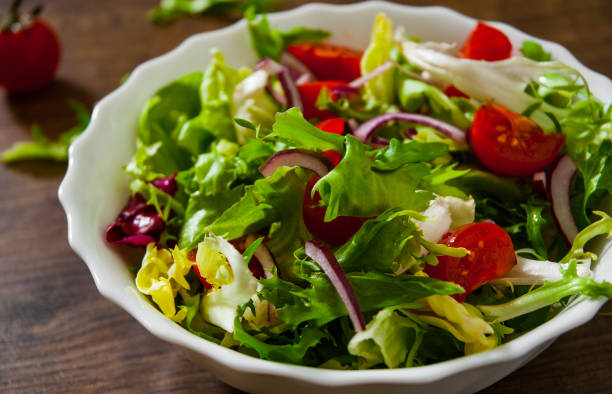 다양 한 신선한 믹스 샐러드 나뭇잎 그릇에 토마토 나무 배경 - salad 뉴스 사진 이미지