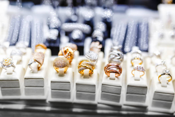 diverse gouden ringen met edelstenen in juwelenwinkel, venster close-up - diamant ring display stockfoto's en -beelden