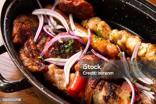 istock Various grilled meat served in deep dish and seasoned with onion slices and parsley 1301553208
