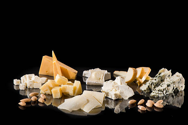 Various types of cheese over black with reflection stock photo