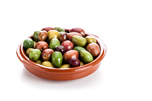 Brown clay bowl filled with various types of fresh olives isolated on white background. Predominant colors are green and brown. Useful copy space available for text and/or logo. High key DSRL studio photo taken with Canon EOS 5D Mk II and Canon EF 100mm f/2.8L Macro IS USM.
