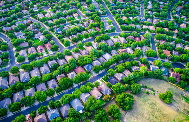 Vast Homes and Thousands of Houses Modern Suburb Development curves layout Vast Homes and Thousands of Houses Modern Suburb Development , green boxes of colorful houses below in a curved modern layout and design aerial drone view from high above suburbia istock images stock pictures, royalty-free photos & images