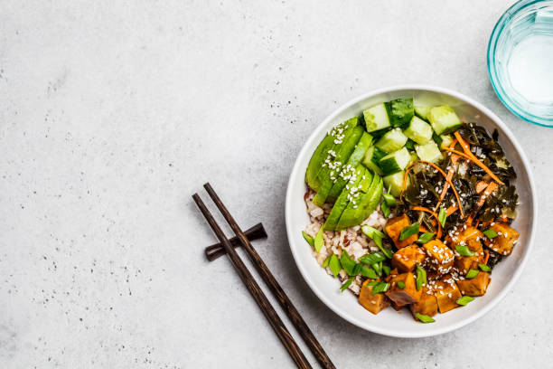 veganistische ahi poke bowl met tofu, rijst, zeewier, avocado en komkommer, witte achtergrond, top view. - vegan keto stockfoto's en -beelden