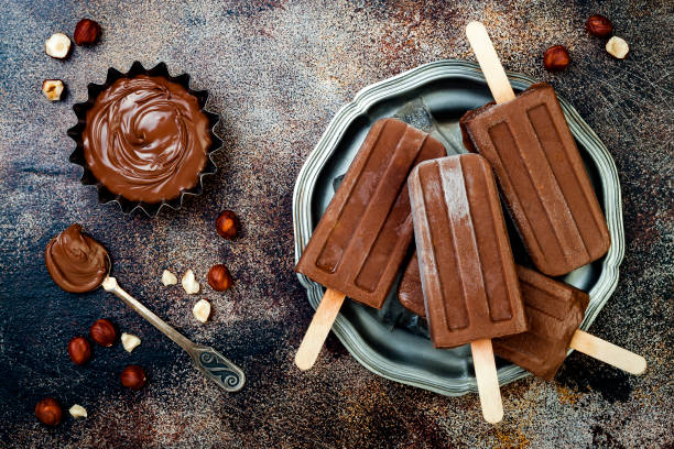 Vegan banana chocolate fudge popsicles with homemade hazelnut spread. Creamy dairy free ice pops, nicecream, fudgesicles Vegan banana chocolate fudge popsicles with homemade hazelnut spread. Creamy dairy free ice pops, nicecream, fudgesicles flavored ice stock pictures, royalty-free photos & images