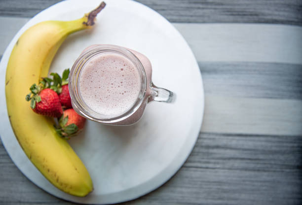 Vegan banana with strawberry smoothie banana, almond milk, strawberries strawberry smoothie stock pictures, royalty-free photos & images