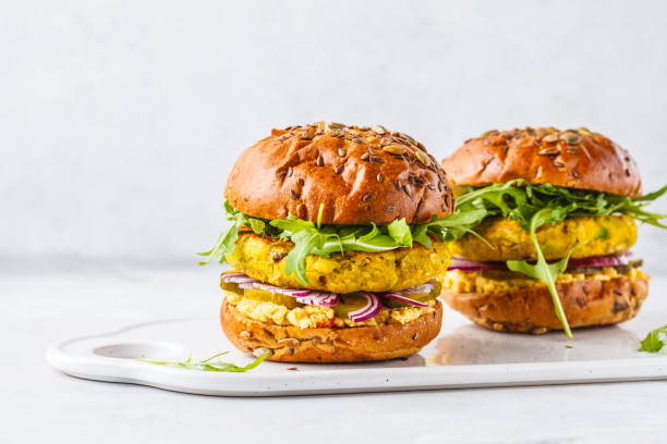 Vegan chickpeas burgers with arugula, pickled cucumbers and hummus, copy space. Vegan chickpeas burgers with arugula, pickled cucumbers and hummus. Plant based diet concept. vegan food stock pictures, royalty-free photos & images