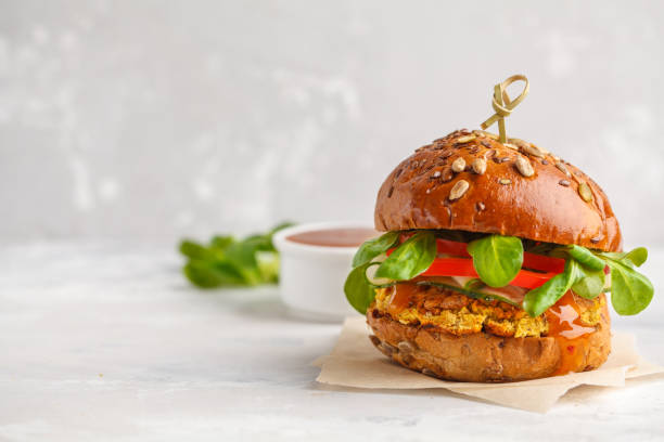 Vegan lentils burger with vegetables and curry sauce. Light background, copy space. Healthy vegan food concept. stock photo