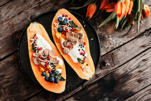 Vegan Papaya Boats – the new kind of breakfast buddha bowls Delicious Papaya Boats – the new kind of breakfast bowls papaya smoothie stock pictures, royalty-free photos & images