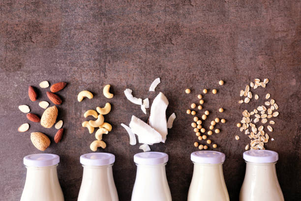 Vegan plant based non dairy milk in milk bottles with ingredients stock photo