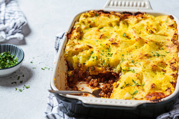 Vegan shepherd's pie with lentils and mashed potatoes in black backing dish. Vegan healthy food concept. stock photo