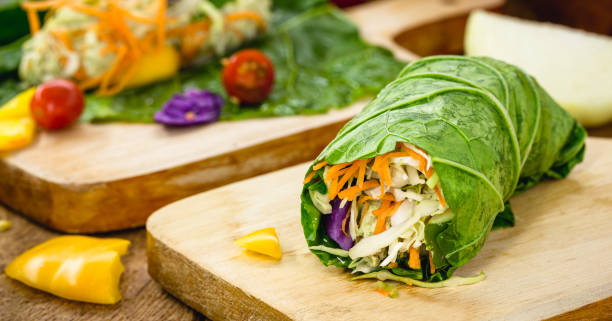 vegan wrap made with kale or lettuce leaf, stuffed with various vegetables, healthy fast food stock photo
