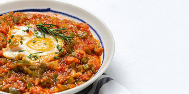 Vegetable dish pisto manchego made of tomatoes, zucchini, peppers, onions with fried egg stock photo