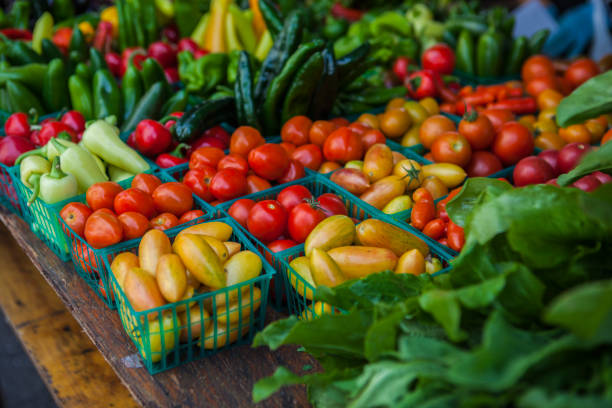 Vegetables on market stall Vegetables with various tomatoes, pimentos and lettuce on market stall. farmer's market stock pictures, royalty-free photos & images