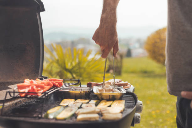 Vegetarian BBQ on weekend. Grill cheese and vegetables on gas grill. Outdoors. stock photo