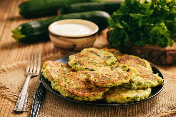 Vegetarian food - zucchini fritters on wooden background. stock photo