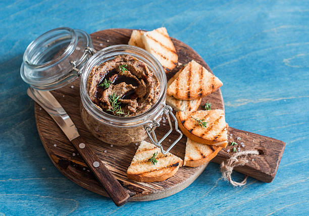 Vegetarian snack - beans and mushroom pate on wooden board Vegetarian snack - beans and mushroom pate on wooden board on blue background pate stock pictures, royalty-free photos & images
