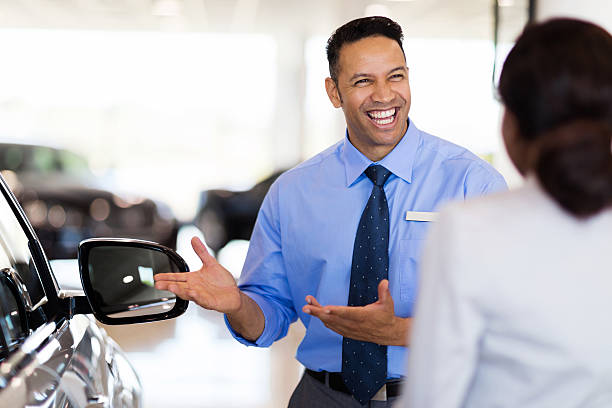 vehicle dealer showing young woman new car stock photo