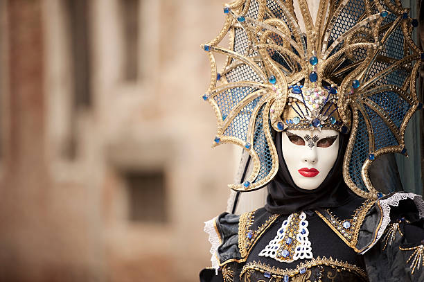 Venice Carnival 2014 Portrait of an attractive masked female person in blue carnival costume and amazing headdress posing at stone arch in Venice, Italy. mardi gras women stock pictures, royalty-free photos & images