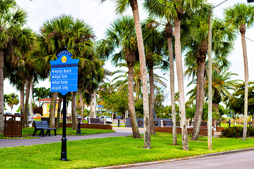 Venice, Florida retirement city town in gulf of Mexico with palm trees on street with information direction sign to beach, Higel park and south jetty boat ramp