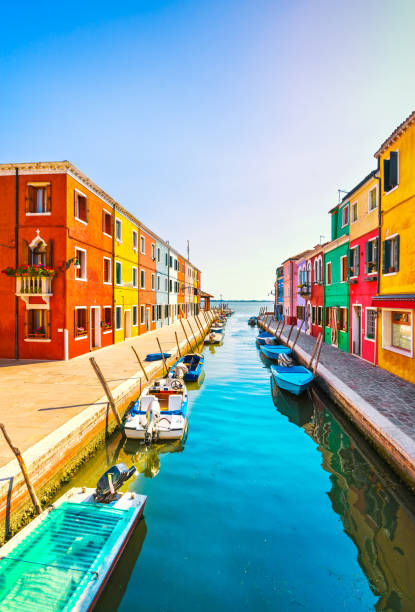 punto di riferimento di venezia, canale dell'isola di burano, case colorate e barche, italia - burano foto e immagini stock