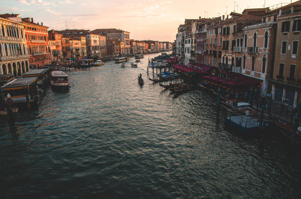 Venice sunset with a gondola on the background of the canal and buildings stock photo