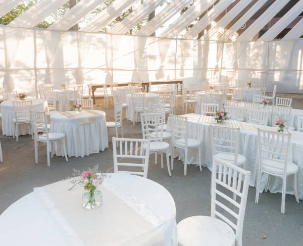 A venue for a wedding in white An outdoor venue for a white wedding, on a bright sunny day greenhouse table stock pictures, royalty-free photos & images