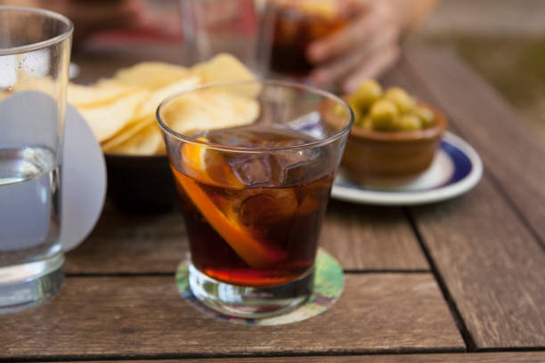 Vermouth and tapas concept Glass of vermouth alcoholic drink with an orange peel on a tapas bar with olives and chips. Traditional vermouth hour concept. vermouth stock pictures, royalty-free photos & images
