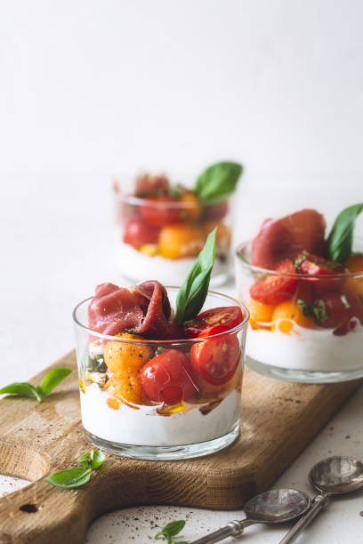 Verrine melon cantaloupe, tomatoes, ricotta cheese, Parma ham and Basil Verrine Melon Cantaloupe, Tomatoes, Ricotta Cheese, Parma Ham and Basil aperitif stock pictures, royalty-free photos & images