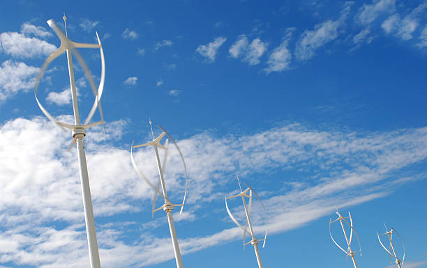 Vertical axis energy wind turbines (rotating) Vertical axis energy wind turbines (rotating) - Motion blur - Copy space - Blue sky vertical axis wind turbine stock pictures, royalty-free photos & images