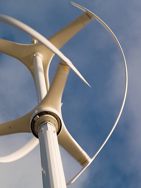 Vertical axis wind turbine rotating with motion blur Vertical axis wind turbine revolving in a brisk wind with motion blur vertical axis wind turbine stock pictures, royalty-free photos & images