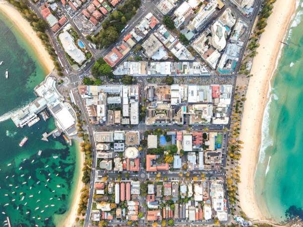 Vertical bird's eye aerial drone panoramic view of the oceanside suburb of Manly, Sydney, New South Wales, Australia. Harbourside on the left, oceanside with famous Manly Beach on the right side. stock photo