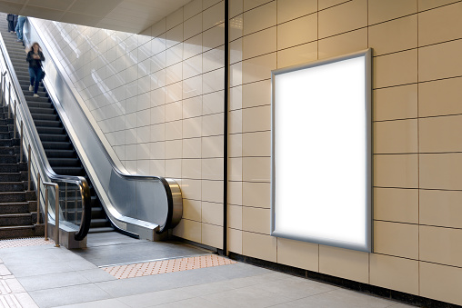Vertical light box poster mockup in metro station, high resolution.