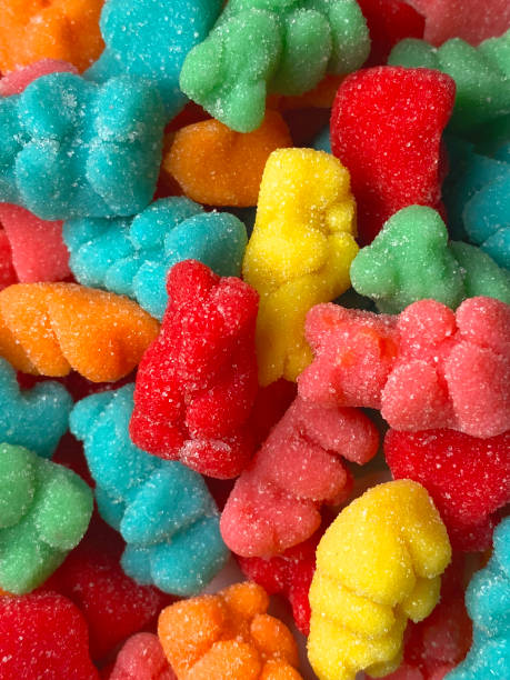 vertical overhead view of sugar covered sour gummy treats in colorful bear shapes stock photo
