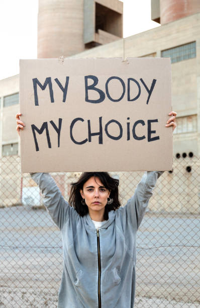 골판지 표지판을 들고 카메라를보고 젊은 백인 여성의 수직 초상화 : 내 몸은 내 선택 - abortion protest 뉴스 사진 이미지