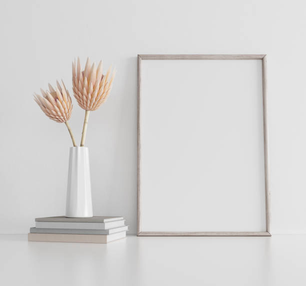 Vertical poster art mockup with wooden frame and dry plant in vase on empty white background. Interior decoration concept 3d render stock photo