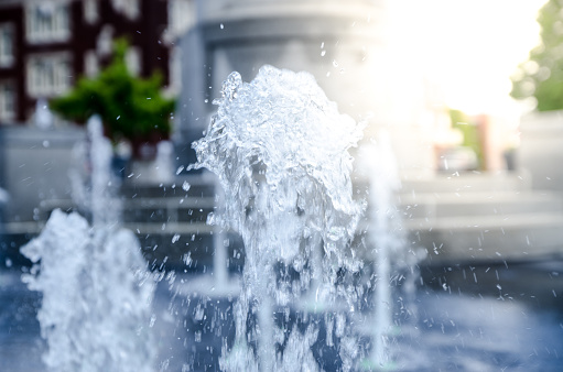 Vertical water jet from public fountain during day of summer with sunlight in Trois-Rivières, Québec, Canada