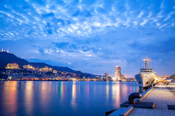Vessel moored in Nagasaki harbor,  Japan at sunset Vessel moored in illuminated Nagasaki harbor, Japan when sunset with beautiful sky nagasaki prefecture stock pictures, royalty-free photos & images